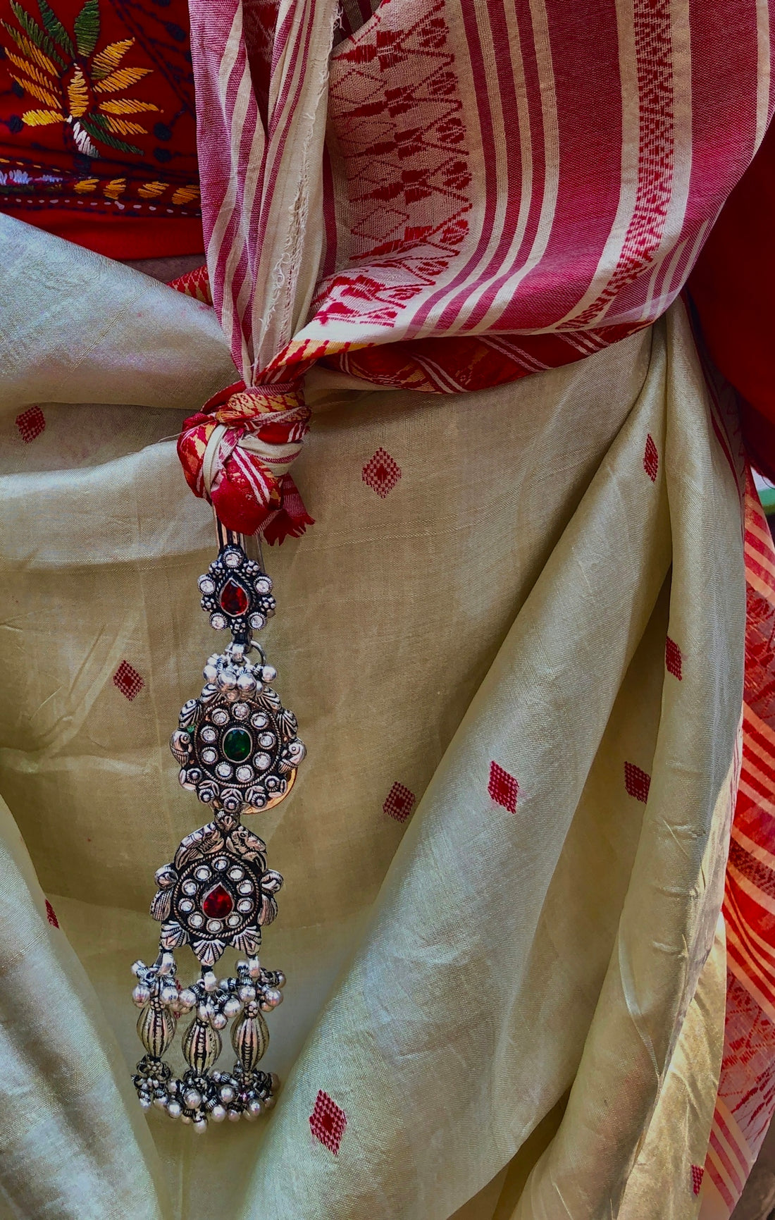 a red and white scarf with a tassel hanging from it