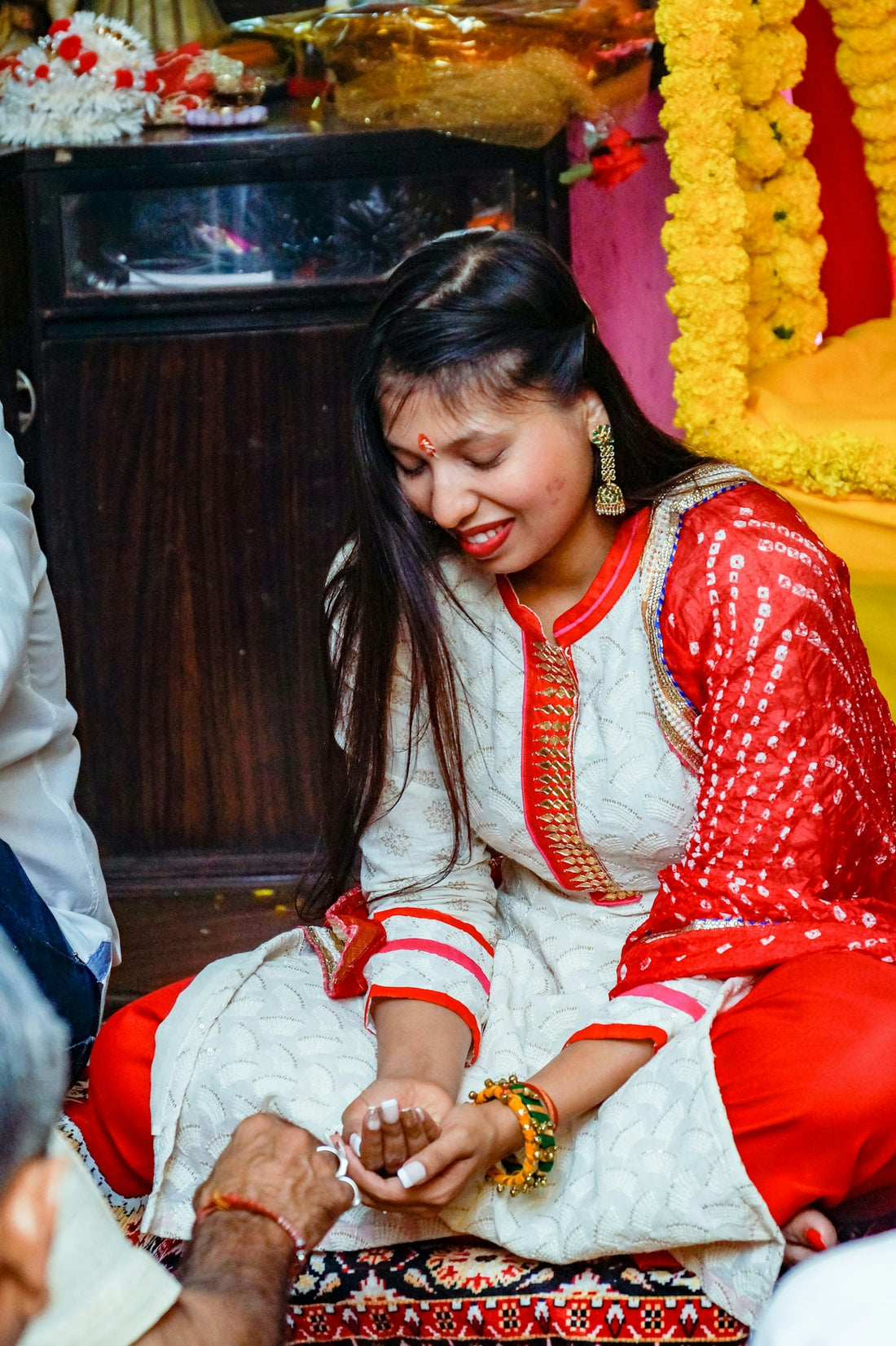 a woman in a red and white dress sitting on the ground