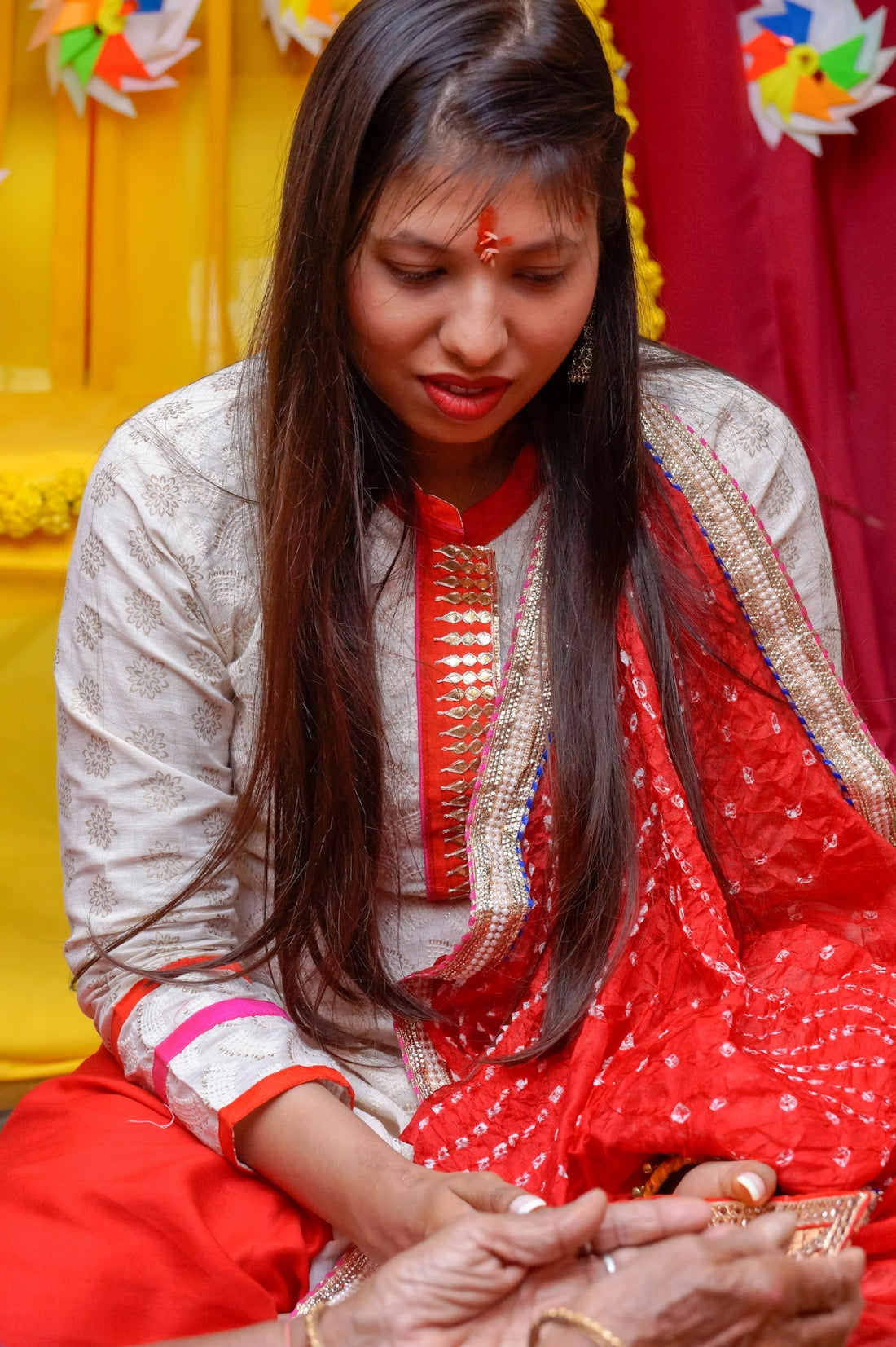 a woman in a red and white outfit sitting down