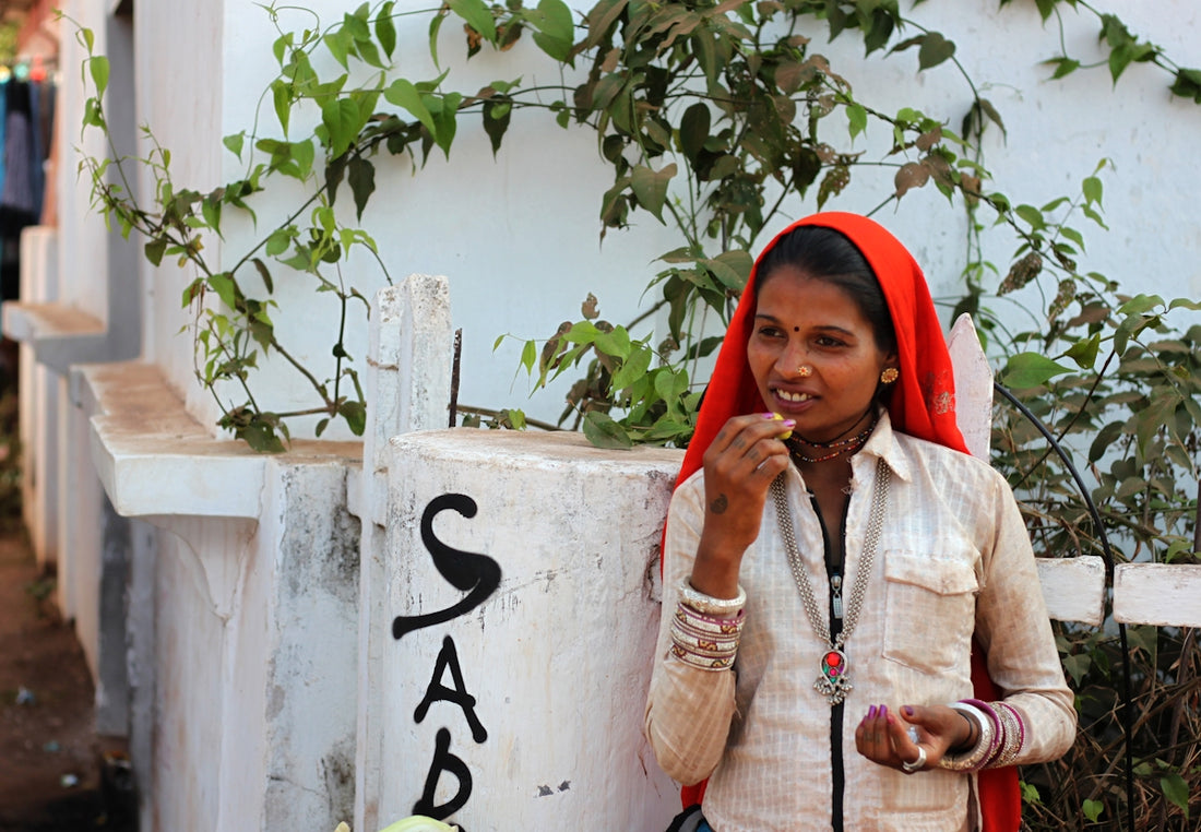 a woman standing next to a wall eating something
