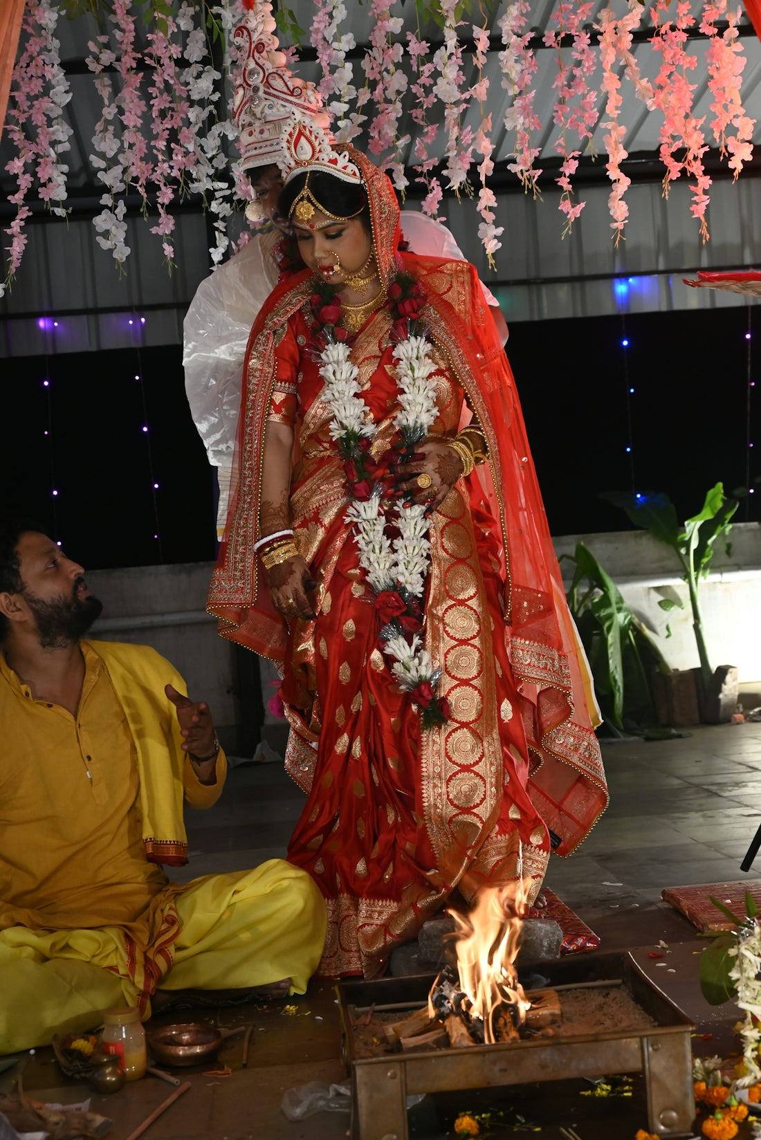 A bengali bride performs a fire ritual during wedding.