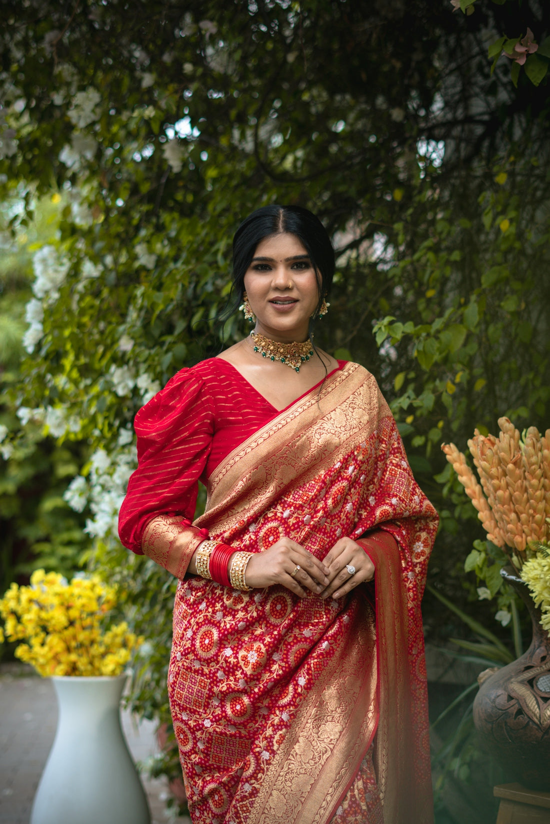 A woman in a red sari poses.