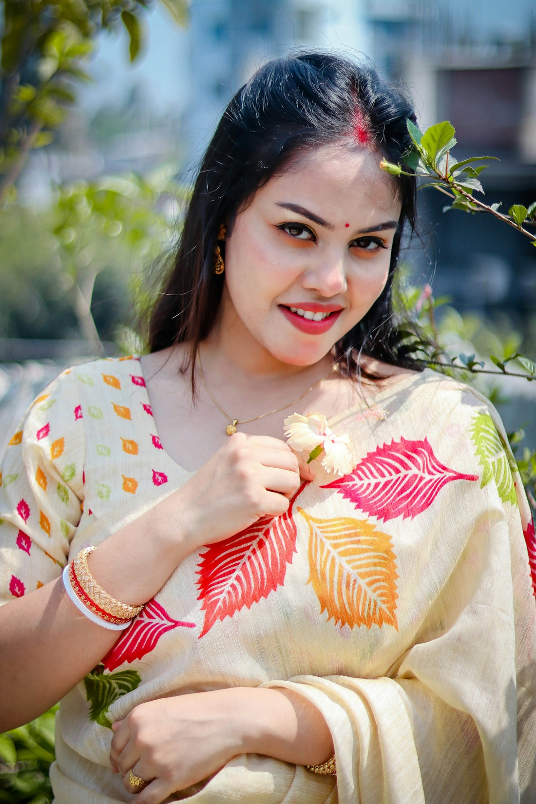 A beautiful woman smiles, wearing a saree.